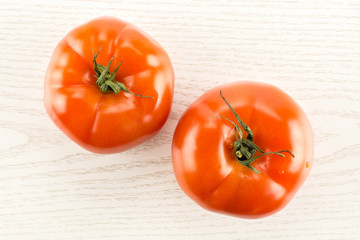 Two red tomato isolated on grey wood background top view.
