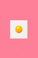 Square egg on pink background. Minimalistic design, colorful background