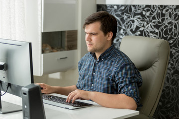 Portrait of young self employed man working at home office on computer