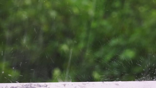 Close up detail shot of torrential raindrops falling on a metal window pane