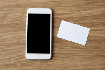 Blank white businesscard and smertphone with blank device screen background, mock up, template for business communication conceprt