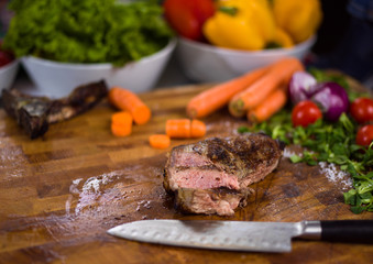 Juicy slices of grilled steak on wooden board
