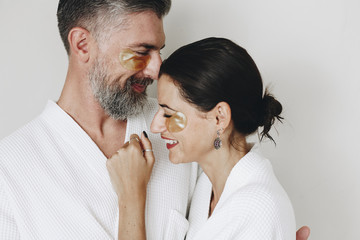 Couple relaxing with golden eye mask treatment - obrazy, fototapety, plakaty