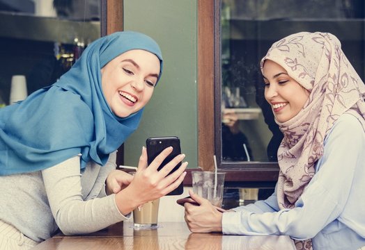 Islamic friends talking and looking on the smart phone