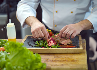 closeup of Chef hands serving beef steak