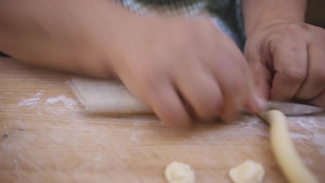Close up, chef cuts pasta dough