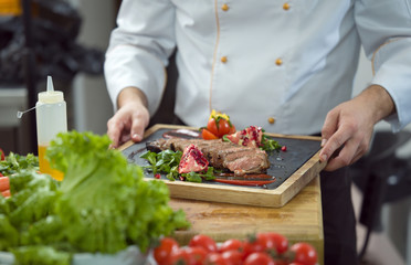 closeup of Chef hands serving beef steak