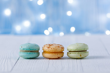 multicolored macaroons on a background of light bulbs