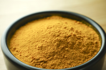curcuma powder in black bowl