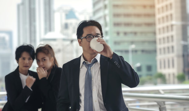 Businessman is being hit by a colleague gossiping behind him.