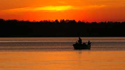 Silhouette of father and son fishing on Lake Irving at sunset in Bemidji, Minnesota.