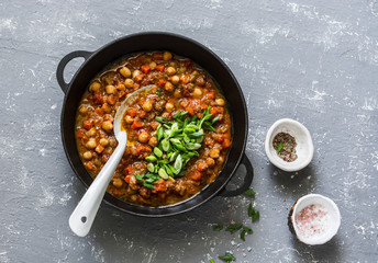 Vegetarian buffalo chickpea chili with mushrooms in a pan on a gray background, top view. Healthy...