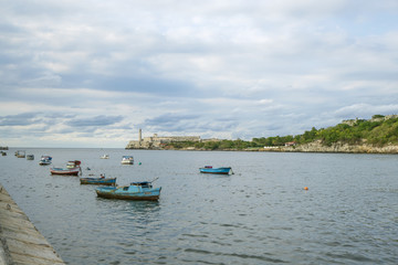 Fototapeta na wymiar Fishing boats at the havana bay with the Morro lighthouse in the background. Havana Cuba. 