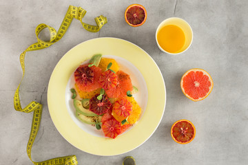 Healthy summer fruit salad oranges grapefruit avocado measuring tape juice Top view flat lay Healthy dietary food concept