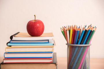 red apple on stack of book with pencil box