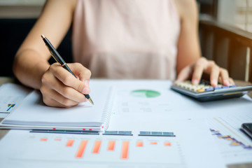 Businesswoman analysis maketing plan, Accountant calculate financial report, with graph chart.  Business, Finance and Accounting concepts