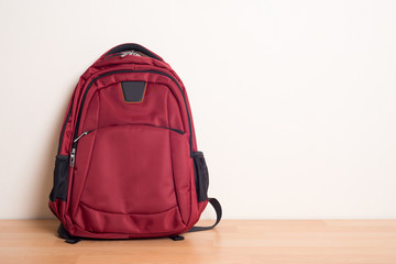 red school bag on wood table