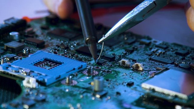 computer upgrade. technician soldering motherboard. technology development. scientific innovation concept