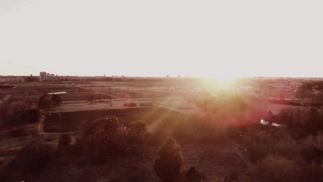 Aerial shot of the sunset with birds flying across the screen.