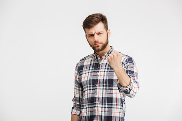 Portrait of an angry young man threatening with a fist