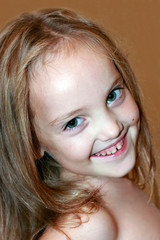 Portrait of a beautiful laughing little girl with a long hair. Close-up