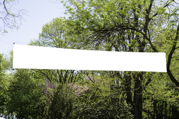 Blank banner floating over the trees with place for your text and advertising.