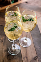 Florence, Tuscany / Italy. - May 14, 2018. A glass of white wine  in a large glass with ice and mint leaves in a bar in Florence, aperitif time