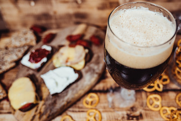 Lager beer mug and snacks on wooden table. Nuts, chips. Top view with copyspace