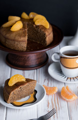 Appetizing pie with tangerines and tasty tea on the table