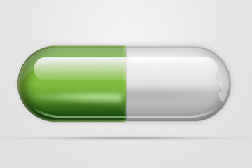 A tablet in the form of capsules of green color, on a light background. The concept of medicine, treatment, treatment.