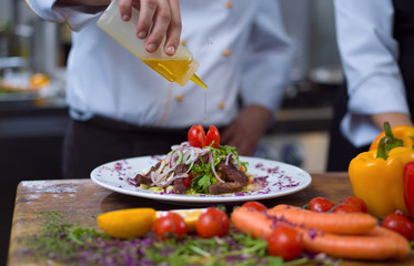 Chef finishing steak meat plate