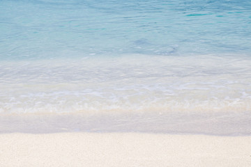Soft wave of blue ocean on sandy beach. Background.
