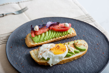 Toast with veggies,avocado, arugula, basil, tomato, mozzarella cheese  and sunny side up egg