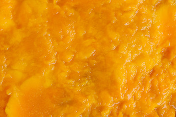 Fototapeta na wymiar Juicy mango fruit pulp making juice and smoothie, background of mango meat close up.