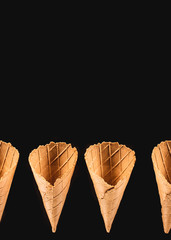 elevated view of row of ice cream cones isolated on black