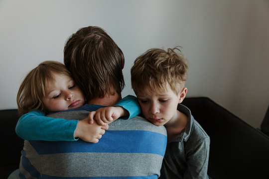 Sad Little Boy And Girl Hugging Father, Family In Sorrow