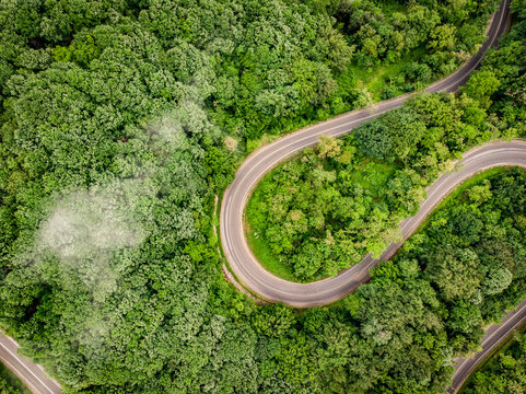 Winding road in the forest aerial view from a drone