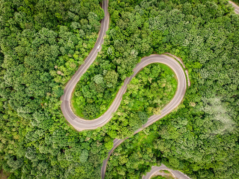 Mountain Road seen from above aerial view over a forest
