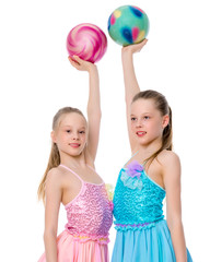 Girls gymnasts perform exercises with the ball.