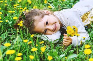 Little girl with dandelions .Funny girl on the grass