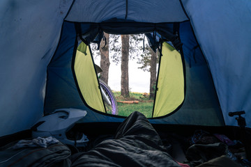 outside my tent view, first person. Camping in forest, motorcycle touring, dual sport enduro, tent and off road adventure motorcycle, active life style concept