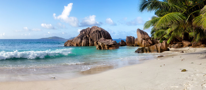 Palmen und Granitfelsen am Traumstrand auf La Digue, Seychellen.