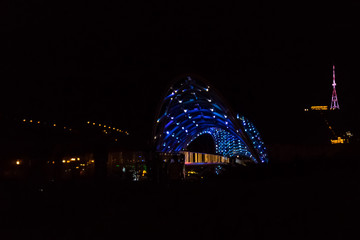 Obraz premium Bridge of Peace in Tbilisi. Pedestrian bridge over the Kura river at night