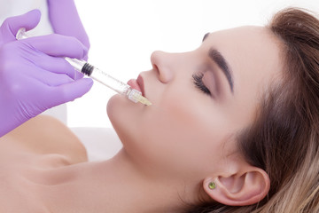 woman receiving a botox injection in her lips, close up.