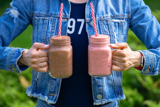 Girl in denim clothes holding two smoothie