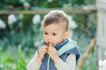 baby, little boy eating a piece of shish kebab meat, outdoors