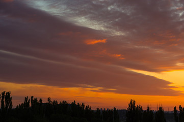 Landscape with dramatic light - beautiful golden sunset with saturated sky and clouds.