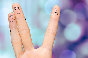 Human hand fingers with funny painted emoticons. People relationships concept