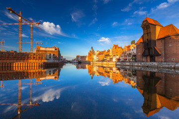 Historic port crane of Gdansk reflected in Motlawa river at sunrise, Poland