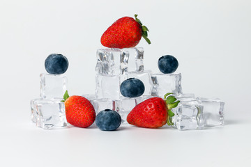 Strawberry blueberry berry read black ice cube on white background